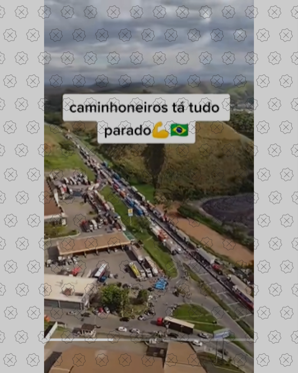 Print de um vídeo mostrando o bloqueio da Via Dutra junto a uma legenda alegando que caminhoneiros estão parando tudo; as imagens foram registradas em outubro de 2022, e não recentemente. 