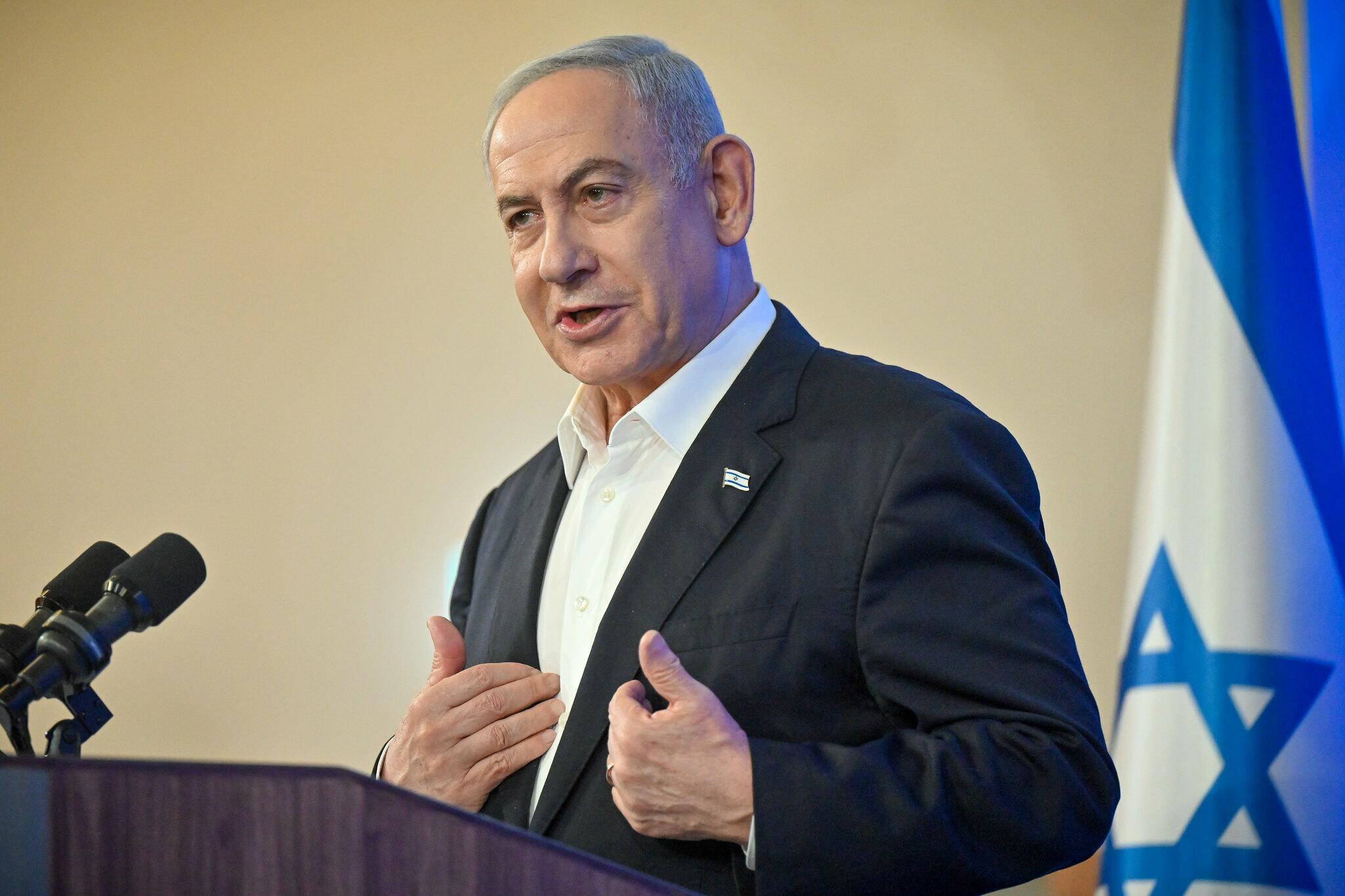 Foto mostra o primeiro-ministro israelense falando; atrás dele há uma bandeira de Israel