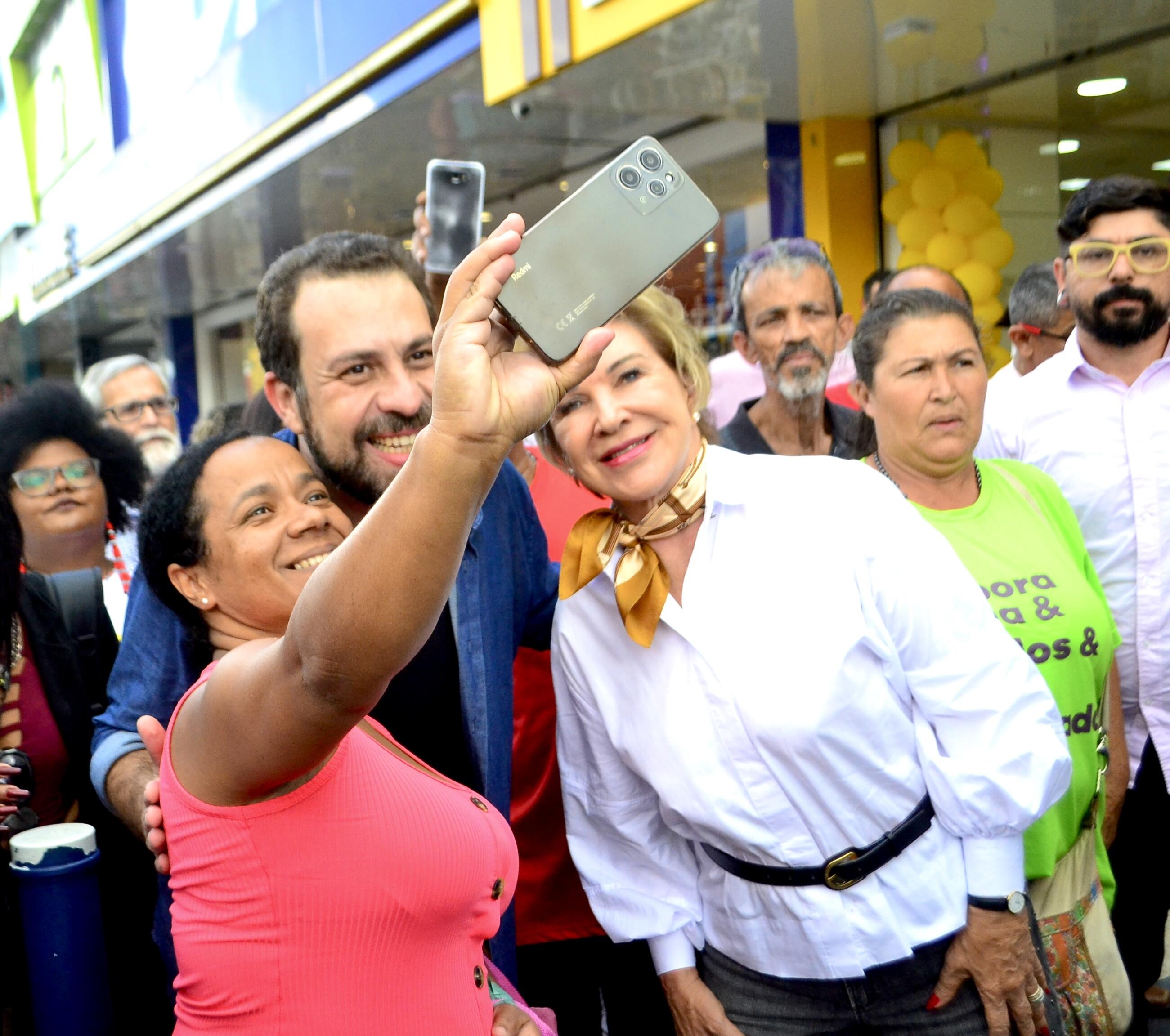 Mulher tira selfie com Boulos e Suplicy em frente a lojas
