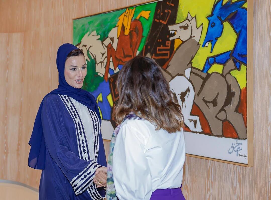 Janja, de costas, cumprimenta sheika Moza bin Nasser, que aparece de frente vestindo uma burca e um vestimental azuis