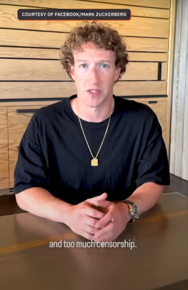 Print de vídeo mostra Mark Zuckerberg, homem loiro, de cabelos cacheados e pele clara, vestindo uma camiseta preta. Ele está sentado atrás de uma mesa e diante de um fundo amadeirado