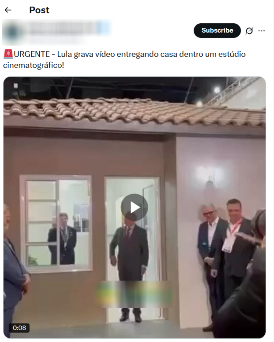 Vídeo que mostra o presidente Lula — homem branco de cabelo e barba grisalha, que usa um terno cinza escuro e gravata vermelha — posando na porta de uma casa cenográfica de cor bege e janelas e porta brancas. Ao redor de Lula aparecem integrantes do governo, também usando trajes formais.