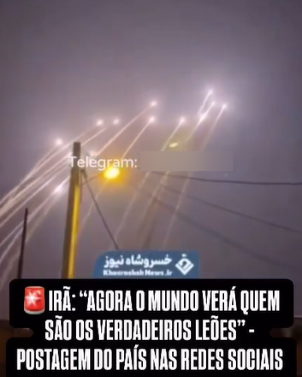 Frame de um vídeo que retrata o lançamento de mísseis balísticos — que aparecem em segundo plano na imagem, como pontos luminosos com rastros curvilíneos de fumaça no céu noturno. Em primeiro plano há postes com fios de energia, que cruzam a imagem. Sobreposta ao vídeo há uma legenda que diz: ‘Irã: Agora o mundo verá quem são os verdadeiros leões — postagem do país nas redes sociais’, além de uma marca d’água da Khosrowshah News, perfil de notícias do Irã.