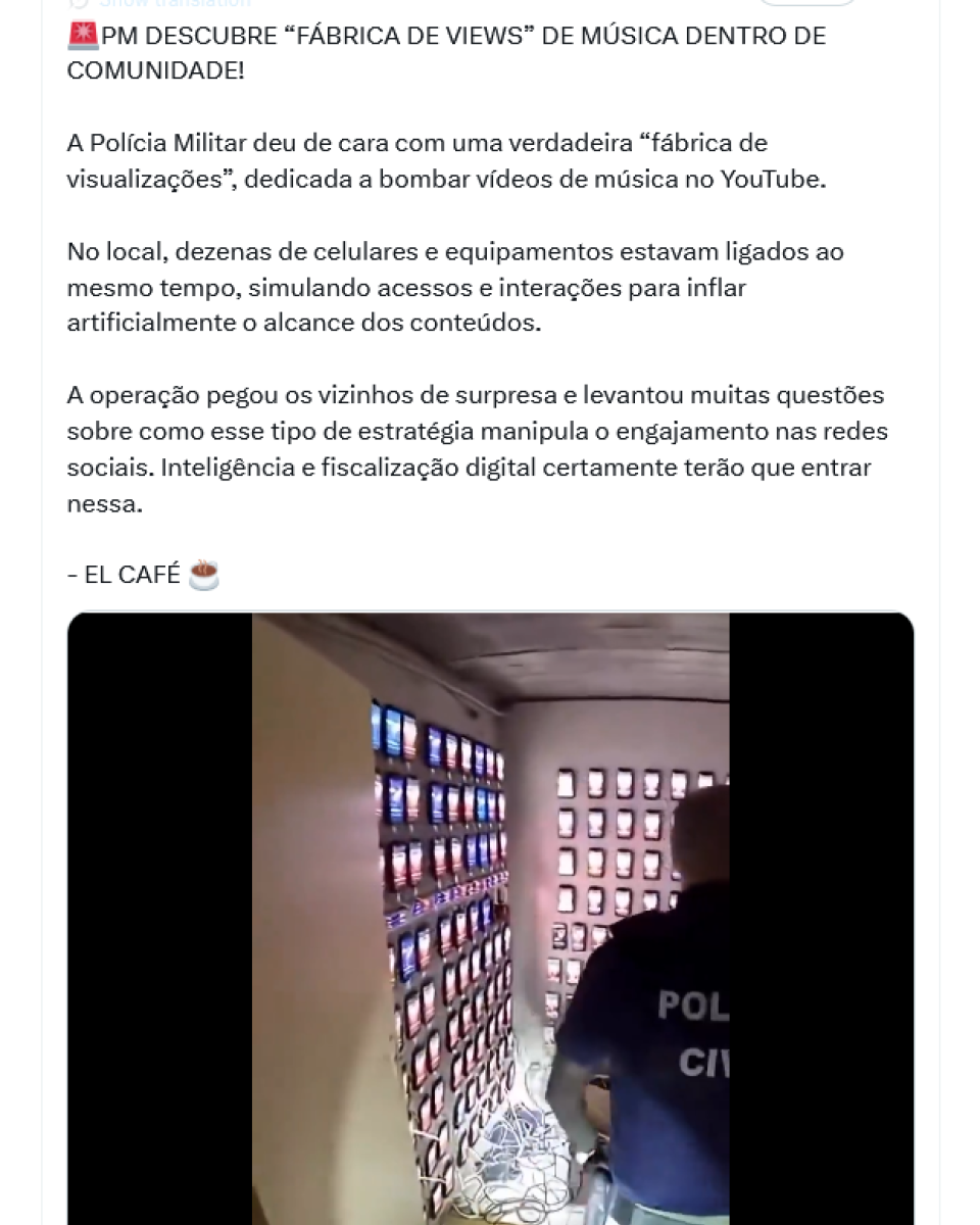 es presos a estruturas nas paredes, todos ligados e com telas acesas; cabos estão organizados ou agrupados no chão e conectados aos aparelhos. Na frente, aparece uma pessoa de costas, usando uma camiseta escura com as palavras ‘Polícia Civil’ estampadas, caminhando em direção ao fundo do local. O texto acima da publicação afirma que a polícia teria encontrado um espaço usado para simular visualizações e engajamento em vídeos de música, operando com vários dispositivos conectados ao mesmo tempo.
