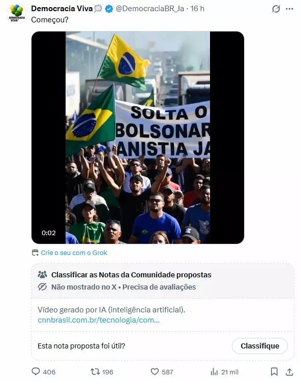 A imagem mostra um grupo numeroso de pessoas reunidas em uma via com veículos ao fundo; algumas delas erguem bandeiras do Brasil em tons de verde, amarelo, azul e branco, enquanto outras seguram um banner branco com texto parcialmente visível. As pessoas apresentam diferentes tons de pele, usam camisetas de cores variadas e estão voltadas para a frente, com expressão neutra ou braços erguidos.