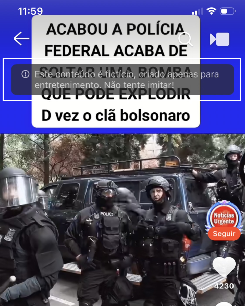 A imagem mostra um vídeo de uma rede social com a tela capturada do aparelho celular, incluindo a hora no topo. Na parte superior do vídeo há um quadro branco com texto em letras maiúsculas afirmando que a Polícia Federal “soltou uma bomba” que pode atingir o “clã Bolsonaro”. Sobre esse quadro, aparece um aviso em transparência informando que “este conteúdo é fictício, criado apenas para entretenimento. Não tente imitar!”.