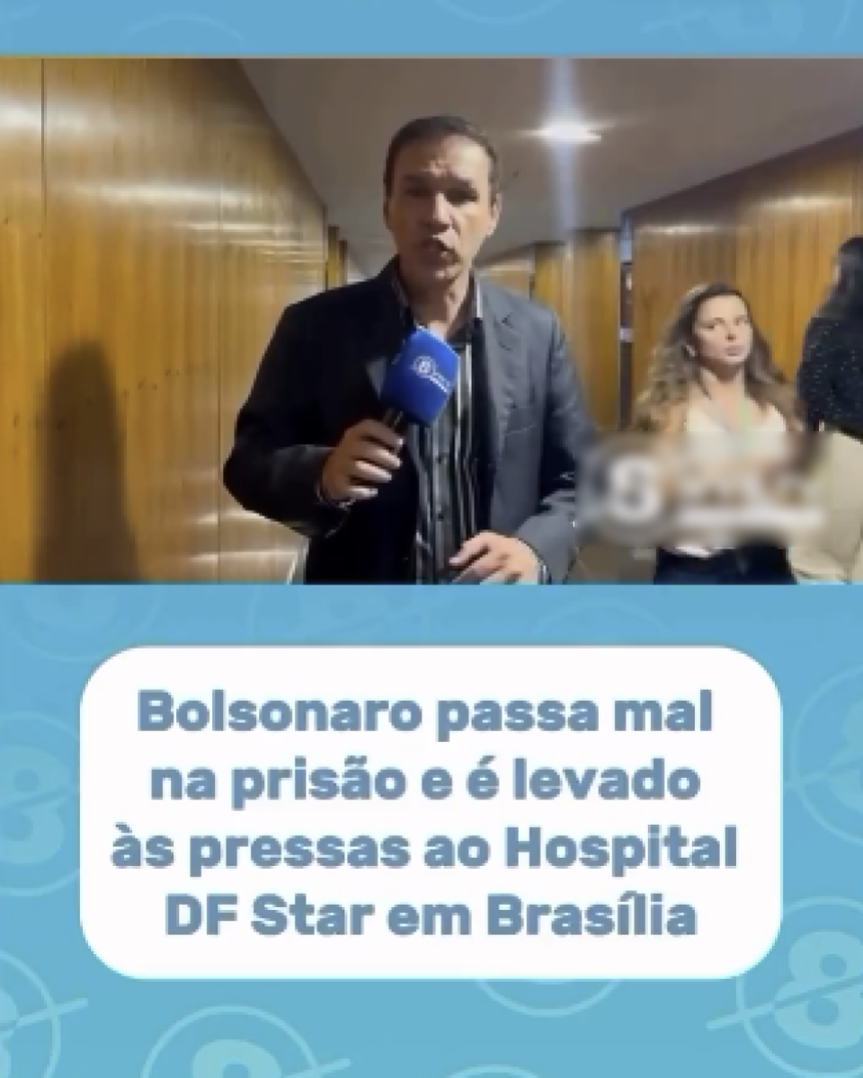 A imagem mostra um homem de pé em um corredor revestido de painéis de madeira, segurando um microfone azul com o logotipo de um veículo de comunicação. Ele usa blazer escuro sobre uma camisa listrada. Atrás dele, duas mulheres caminham pelo corredor, uma usando blusa clara e a outra, parcialmente visível, usando roupa escura. Na parte inferior da imagem há um fundo azul com um quadro branco centralizado contendo o texto: ‘Bolsonaro passa mal na prisão e é levado às pressas ao Hospital DF Star em Brasília’.