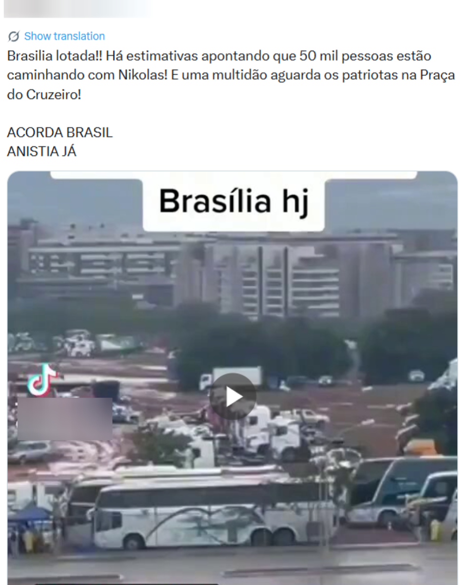 Captura de tela mostra um post no X que afirma que ‘Brasília’ estaria ‘lotada’, menciona ‘estimativas’ de ‘50 mil pessoas’ caminhando ‘com Nikolas’ e diz que ‘uma multidão’ aguardaria ‘os patriotas na Praça do Cruzeiro’, seguida das frases ‘ACORDA BRASIL’ e ‘ANISTIA JÁ’. Abaixo do texto, aparece a prévia de um vídeo com a legenda sobreposta ‘Brasília hj’. Na imagem vê-se uma paisagem urbana ao fundo com prédios altos e, em primeiro plano, uma área ampla com terra exposta e vegetação, onde há diversos veículos estacionados ou em circulação, incluindo ônibus e vans, além de estruturas e tendas