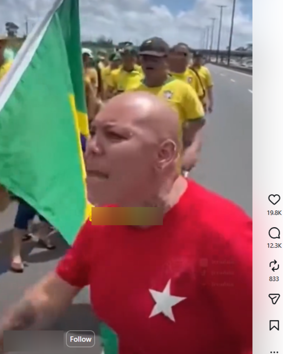 Pessoa de cabeça raspada que veste camiseta vermelha com estrela branca no peito aparece em primeiro plano gesticulando enquanto caminha numa estrada sob céu claro. Atrás dela, há um grupo de pessoas vestidas principalmente de verde e amarelo, algumas com bonés, acompanhando a caminhada.Na parte de baixo, há a legenda: ‘Os petistas estão enlouquecidos’.