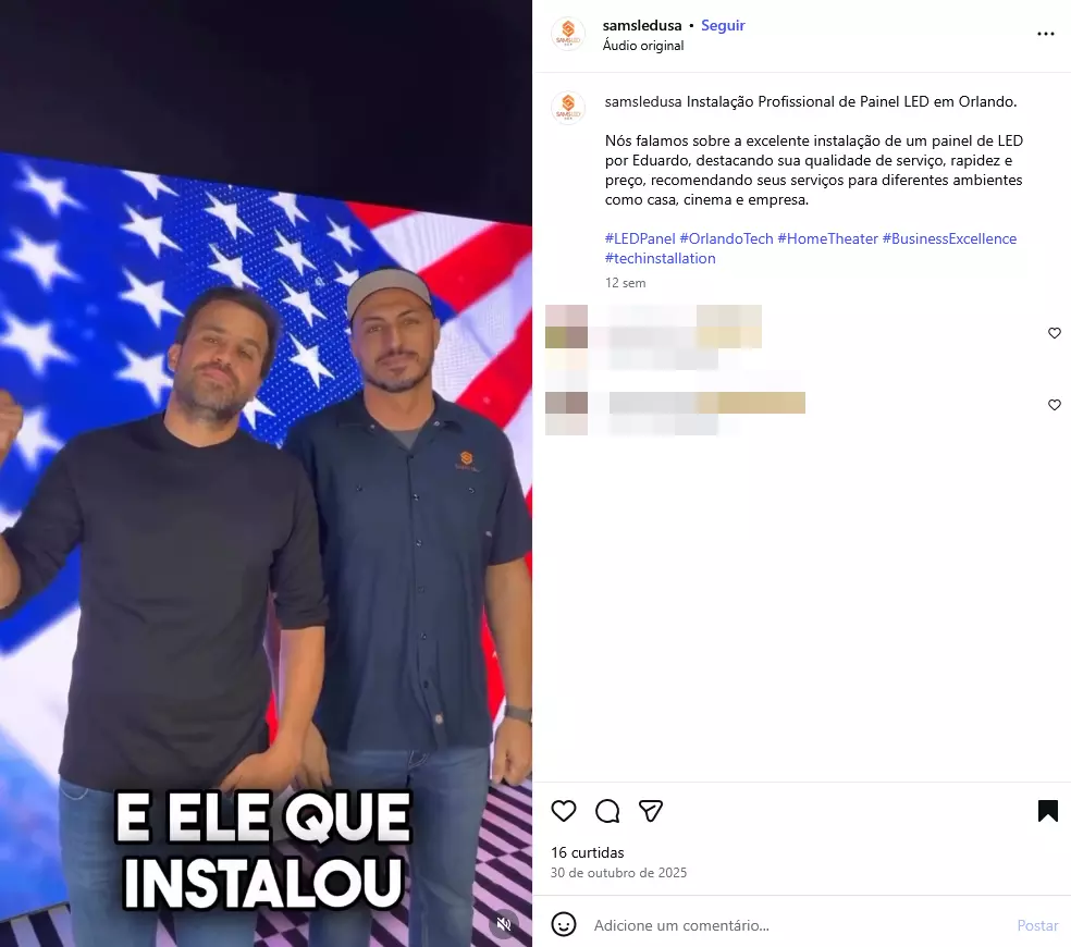 A imagem é uma captura de tela de uma publicação no Instagram que mostra dois homens em pé, lado a lado, diante de um painel de LED exibindo a bandeira dos Estados Unidos. À esquerda, há um homem de pele clara, cabelo curto escuro e barba curta, vestindo camiseta preta de mangas longas, com uma das mãos parcialmente levantada. À direita, há um homem de pele clara, cabelo curto escuro e barba curta, usando camisa azul de mangas curtas com logotipo no peito e um boné claro. Na parte inferior da imagem, aparece o texto gráfico ‘E ELE QUE INSTALOU’. À direita, são visíveis elementos da interface do Instagram, incluindo o nome do perfil, legenda, curtidas e comentários.