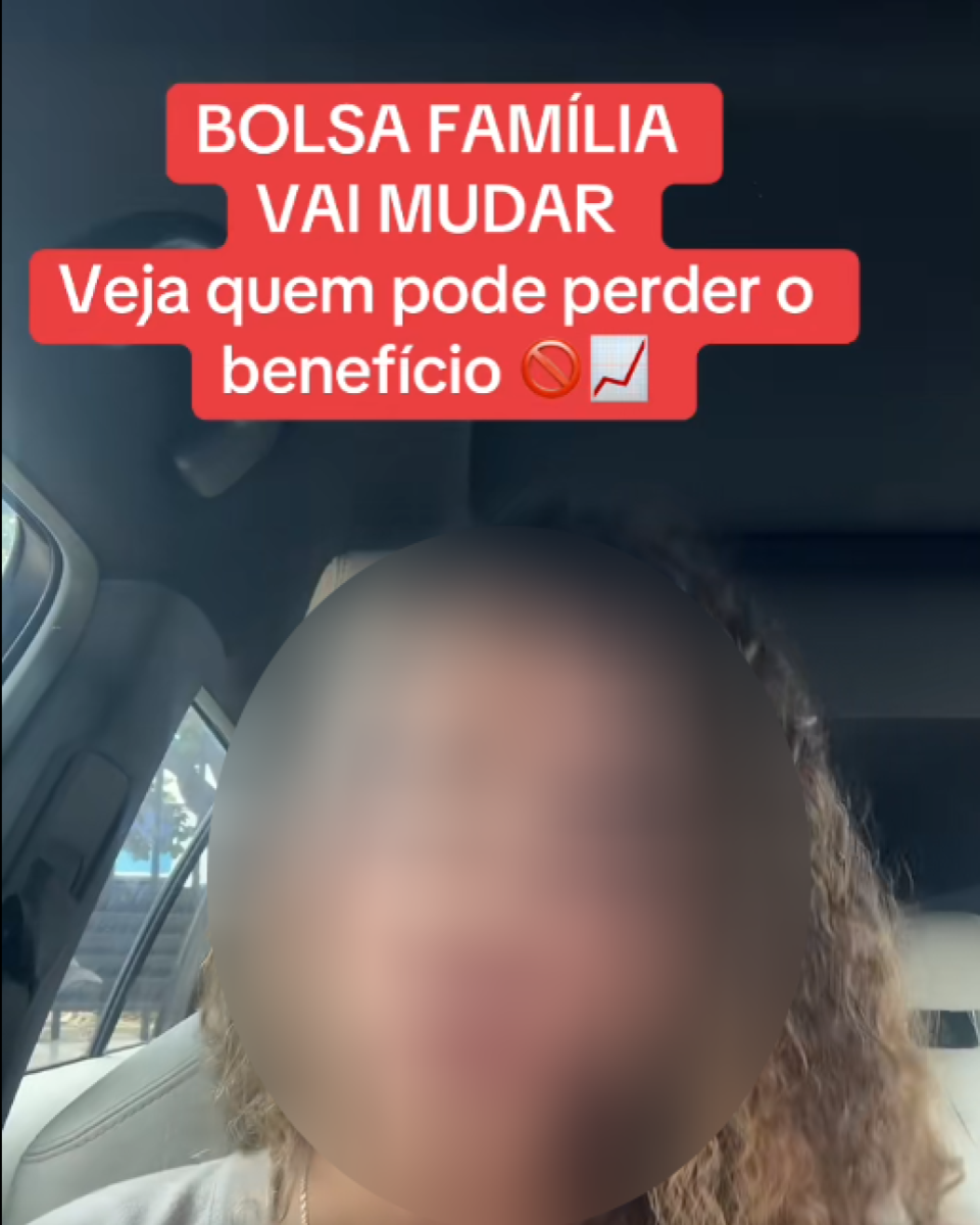 Mulher está sentada no banco dianteiro de um carro, registrada em um vídeo vertical. Seu rosto está desfocado para preservar sua identidade. Na parte superior da imagem, há um texto em destaque sobre um fundo vermelho que diz: ‘BOLSA FAMÍLIA VAI MUDAR. Veja quem pode perder o benefício’.