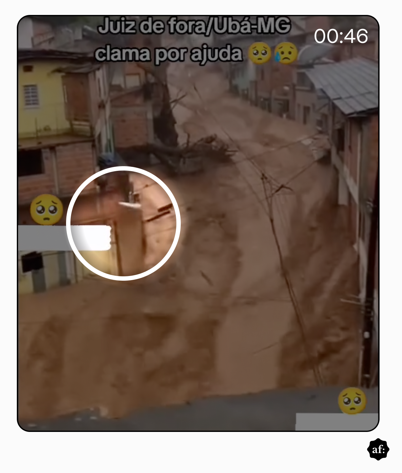 Imagem mostra rua estreita em área urbana com casas de alvenaria de dois andares, com fachadas em tijolo aparente e paredes pintadas em tons claros, enquanto uma enxurrada de lama marrom ocupa quase toda a via, formando correntes e redemoinhos.