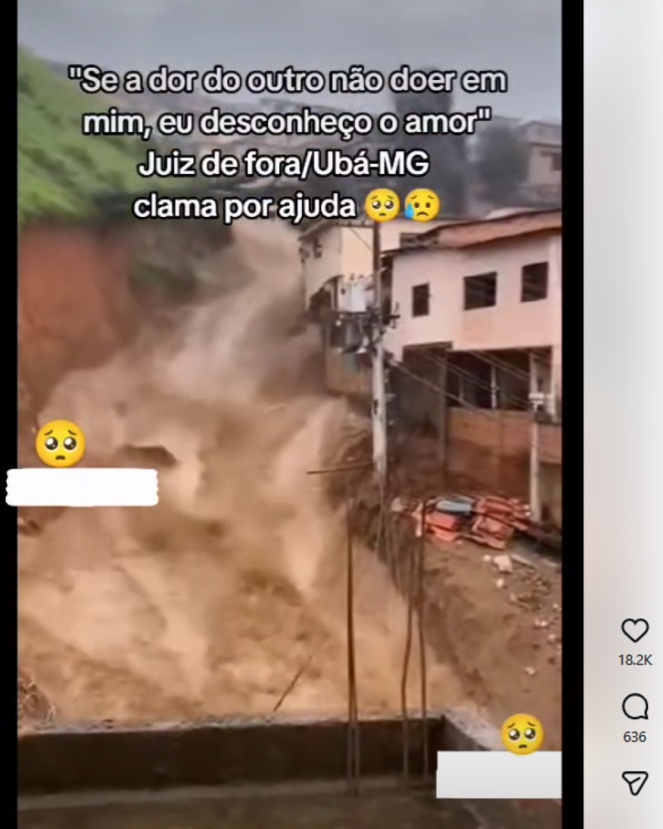 Deslizamento de terra avança por encosta urbana, com grande volume de lama descendo em direção a casas próximas. Um poste com fiação aparece no centro e, à direita, há construções de dois andares junto ao barranco. Sobre o vídeo, há texto afirmando que ‘Juiz de fora/Ubá-MG clama por ajuda.’