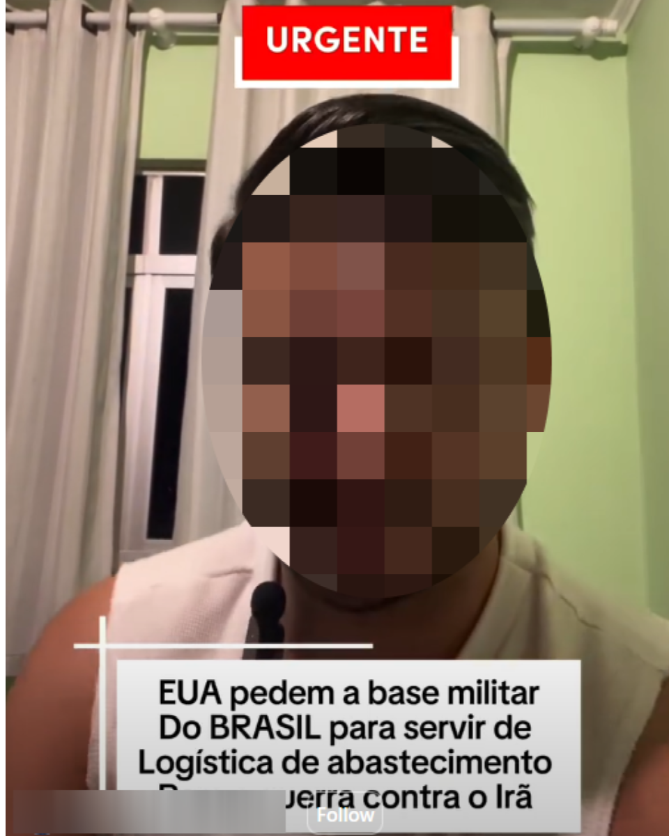 Homem com o rosto desfocado para preservar identidade está sentado em ambiente interno diante de câmera. Ele veste camiseta clara sem mangas e aparece diante de parede verde-clara, com janela ao fundo coberta por cortinas claras. Na parte superior da imagem, há um banner vermelho com o texto: ‘URGENTE’. Na parte inferior, outro texto afirma: ‘EUA pedem a base militar do BRASIL para servir de logística de abastecimento para guerra contra o Irã’.