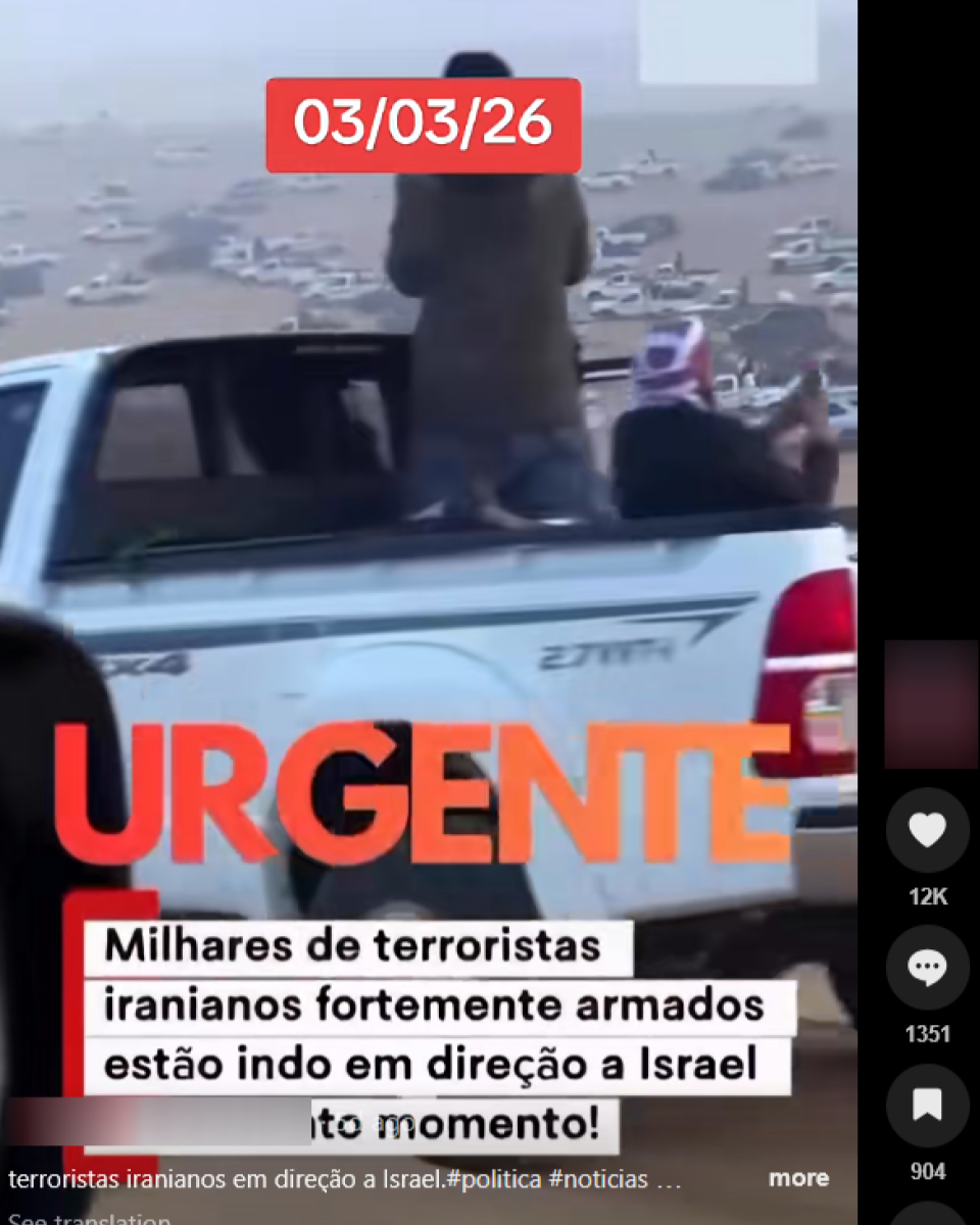 Caminhonete branca circula por estrada de terra em área aberta e árida, com diversos veículos espalhados ao fundo. Na caçamba do veículo, aparecem duas pessoas: uma em pé, usando roupa escura e cobrindo parcialmente a cabeça, e outra sentada, com um pano ou lenço envolvendo a cabeça e parte do rosto. Sobre o vídeo, há textos em destaque que dizem ‘03/03/26’ e ‘URGENTE’, além da frase: ‘Milhares de terroristas iranianos fortemente armados estão indo em direção a Israel neste momento!’.