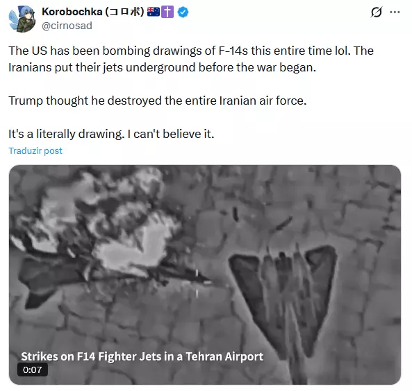 Publicação no X. No topo, aparece o perfil ‘Korobochka (@cirnosad)’, acompanhado de emojis de bandeiras e um símbolo religioso. O texto da publicação, em inglês, afirma que os Estados Unidos estariam bombardeando desenhos de aviões F-14 e que aeronaves iranianas teriam sido colocadas no subsolo antes da guerra. Abaixo, há a miniatura de um vídeo em preto e branco que parece ser uma imagem aérea ou de sensor térmico de um ataque, mostrando duas formas no chão semelhantes a aviões e uma área com fumaça ou explosão. No canto inferior do vídeo aparece o texto ‘Strikes on F14 Fighter Jets in a Tehran Airport’.