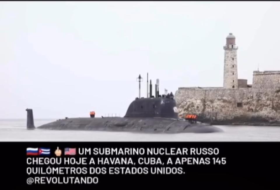 Imagem dividida em duas partes. A parte superior mostra um submarino escuro na água. Ao fundo, do lado direito, vê-se um paredão de pedra de uma fortaleza e um farol branco sob um céu nublado. A parte inferior possui um fundo preto com o seguinte texto escrito em letras brancas maiúsculas: ‘[Emoji da bandeira da Rússia] [Emoji da bandeira de Cuba] [Emoji de um dedo do meio] [Emoji da bandeira dos Estados Unidos] UM SUBMARINO NUCLEAR RUSSO CHEGOU HOJE A HAVANA, CUBA, A APENAS 145 QUILÔMETROS DOS ESTADOS UNIDOS’,  o que é falso. A frota russa chegou a enseada de Havana em junho de 2024 e ficou quatro dias no local.