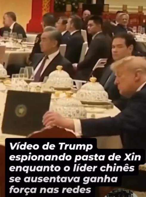 Captura de tela de banquete formal mostra Donald Trump em primeiro plano, sentado em mesa decorada com pratos ornamentados. Ele aparece inclinado para a frente, mexendo em uma pasta sobre a mesa, enquanto um homem de terno ao seu lado olha para a frente. Ao fundo, outros convidados aparecem desfocados no salão. Na parte inferior da imagem, texto diz: ‘Vídeo de Trump espionando pasta de Xin enquanto o líder chinês se ausentava ganha força nas redes’.