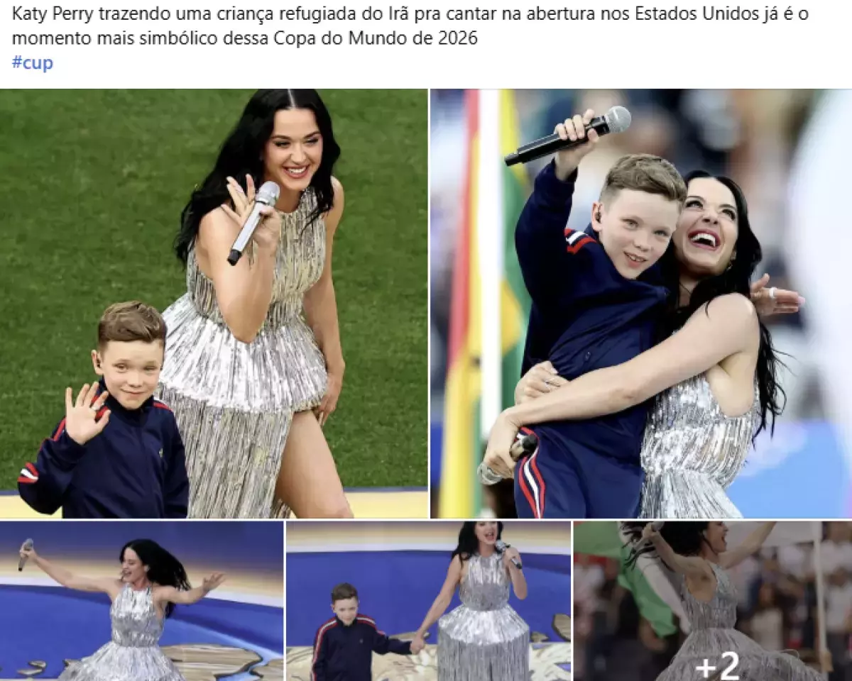 A imagem é uma montagem composta por cinco fotografias organizadas em um mosaico. Na parte superior há um texto em fundo branco que diz: 'Katy Perry trazendo uma criança refugiada do Irã pra cantar na abertura nos Estados Unidos já é o momento mais simbólico dessa Copa do Mundo de 2026 #cup'. As fotos mostram a cantora, uma mulher de cabelos longos e pretos, usando um vestido prateado brilhante e segurando um microfone. Ela está ao lado de uma criança de cabelos claros vestida com um conjunto azul-escuro com detalhes vermelhos. Em uma das imagens, os dois caminham sobre um gramado enquanto acenam; em outra, ela abraça a criança e ambos seguram microfones, sorrindo para o público. Nas imagens da faixa inferior, Katy aparece cantando com os braços abertos, segurando a mão da criança ou se apresentando sozinha. O fundo das fotos mostra um estádio, com áreas de gramado verde, arquibancadas desfocadas e partes de uma estrutura colorida. No canto inferior direito do mosaico aparece o símbolo '+2', indicando que há mais imagens associadas à publicação.