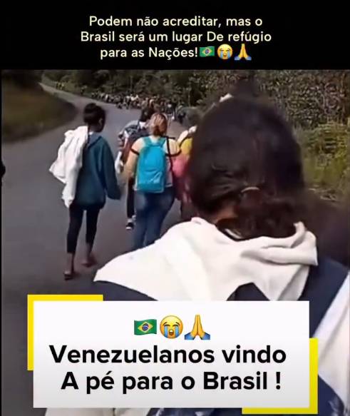Uma captura de tela exibe uma cena de pessoas caminhando por uma estrada. Na parte superior, sobre um fundo preto, há o texto em branco: 'Podem não acreditar, mas o Brasil será um lugar De refúgio para as Nações!', seguido por emojis da bandeira do Brasil, um rosto amarelo chorando e mãos unidas em prece. A imagem principal mostra um grupo de indivíduos caminhando de costas para a câmera em uma via asfaltada ladeada por vegetação. Em primeiro plano, destaca-se uma pessoa com cabelos escuros amarrados, vestindo um casaco claro com capuz e carregando uma mochila azul com alças escuras. Logo à frente, à esquerda, outra pessoa veste uma blusa azul-escura e calça escura, carregando um tecido claro sobre o ombro; ao centro, uma terceira pessoa carrega uma mochila azul-clara. Várias outras pessoas são vistas caminhando mais adiante na estrada. Na parte inferior, sobreposta à imagem, há uma caixa branca com detalhes geométricos amarelos nas bordas. Dentro da caixa, repetem-se os emojis da bandeira, do rosto chorando e das mãos em prece, posicionados acima do texto em letras pretas: 'Venezuelanos vindo A pé para o Brasil !'.