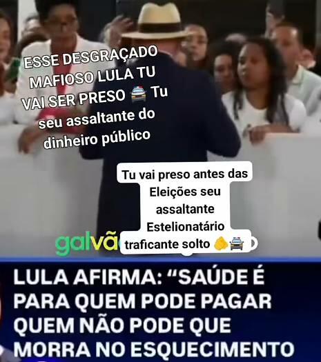 Uma captura de tela vertical está dividida em duas partes. A parte superior exibe uma pessoa de costas, vestindo terno escuro e chapéu claro, de pé diante de uma barreira branca onde um grupo de pessoas a observa. A parte inferior da imagem simula uma tarja de telejornal com fundo azul-escuro e o seguinte texto em grandes letras maiúsculas brancas: ‘LULA AFIRMA: SAÚDE É PARA QUEM PODE PAGAR QUEM NÃO PODE QUE MORRA NO ESQUECIMENTO’. 