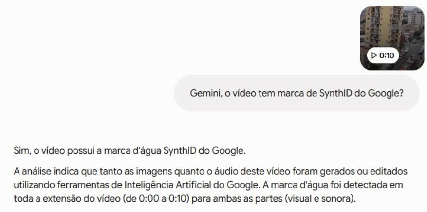 A imagem é uma captura de tela de uma conversa com o Gemini. Na parte superior direita há uma miniatura de um vídeo de dez segundos mostrando um edifício alto aparentemente danificado. Na conversa, aparece a pergunta: 'Gemini, o vídeo tem marca de SynthID do Google?'. A resposta exibida afirma que sim, dizendo que o vídeo possui uma marca-d'água SynthID do Google e que a análise indica que tanto as imagens quanto o áudio foram gerados ou editados com ferramentas de inteligência artificial do Google. O texto também afirma que a marca-d'água foi detectada durante toda a extensão do vídeo, de 0:00 a 0:10, tanto nas partes visuais quanto sonoras.