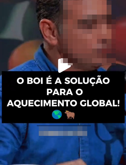 A imagem exibe um homem — de pele clara, cabelo curto escuro e vestindo uma camisa jeans azul de botões —, que tem a metade direita de seu rosto propositalmente obscurecida por um efeito de pixelização. No centro da composição, sobreposto ao peito do homem, há um ícone de reprodução de vídeo branco localizado logo acima de um bloco retangular preto. Dentro desse bloco escuro, consta o seguinte texto em letras maiúsculas brancas: 'O BOI É A SOLUÇÃO PARA O AQUECIMENTO GLOBAL!', seguido pelos emojis de um globo terrestre e de um boi. Abaixo da caixa preta, observa-se uma pequena área retangular borrada, enquanto o fundo da cena se apresenta escuro e fora de foco.