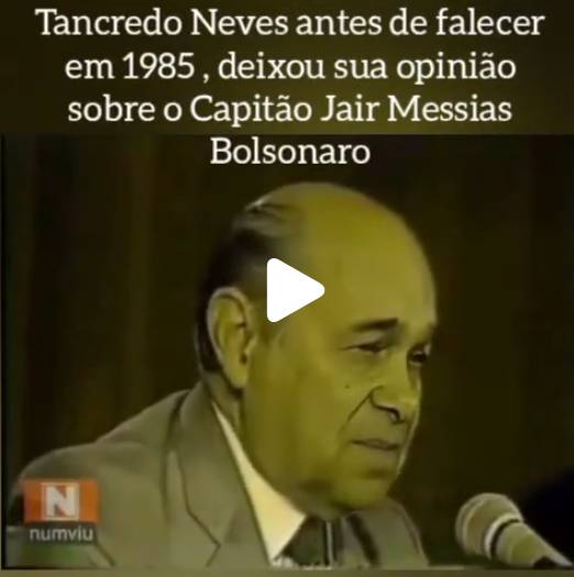Imagem exibe uma captura de tela de um vídeo cujo centro mostra um homem idoso de pele clara, calvo com pouco cabelo escuro nas laterais, vestindo um terno cinza-claro, camisa branca e gravata escura. Ele está olhando ligeiramente para baixo, com um microfone posicionado à sua frente no canto inferior direito, enquanto um ícone de reprodução de vídeo branco aparece sobreposto em seu rosto. No canto inferior esquerdo, há um logotipo composto por um quadrado laranja com a letra 'N' em branco e a palavra 'numviu' escrita logo abaixo. Na parte superior da imagem, sobre um fundo escuro, lê-se o seguinte texto em letras claras: 'Tancredo Neves antes de falecer em 1985, deixou sua opinião sobre o Capitão Jair Messias Bolsonaro'.