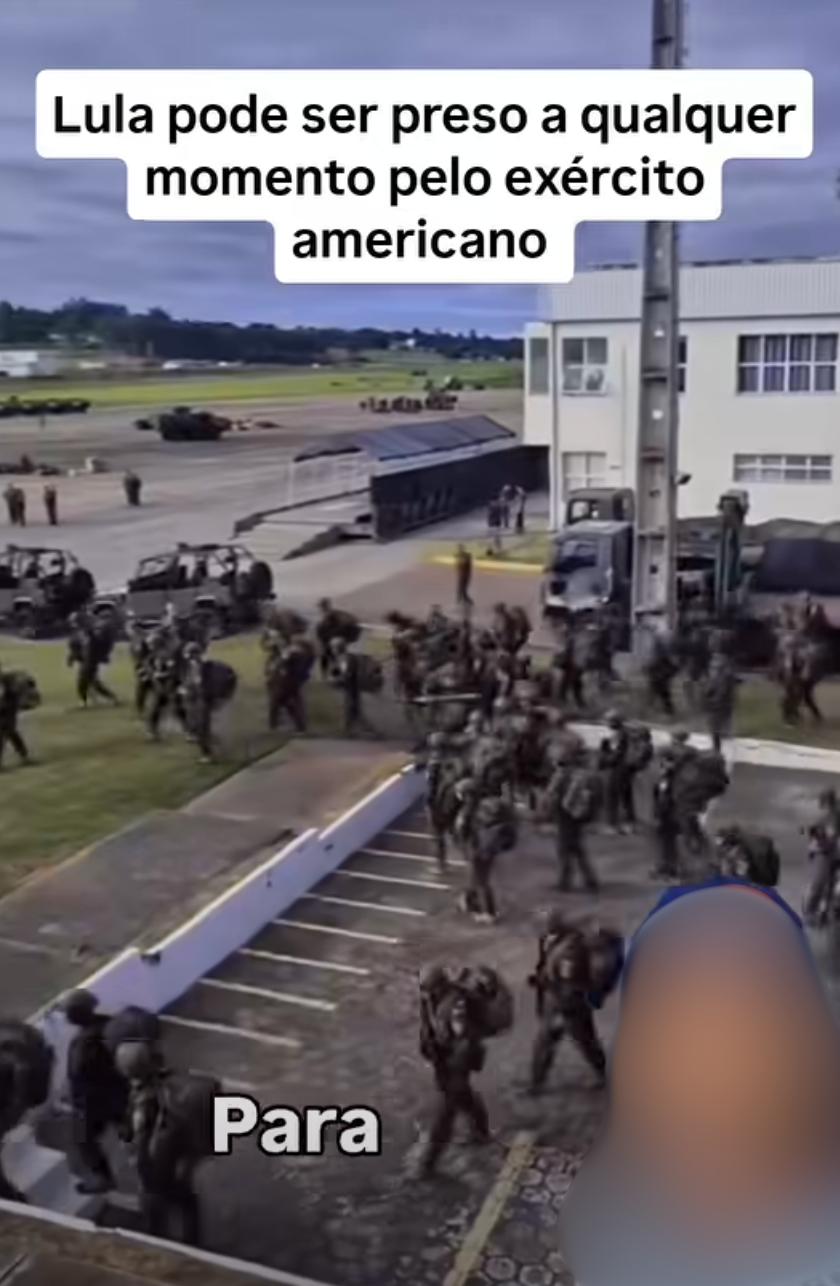 Visão aérea de um pátio militar com vários soldados fardados e equipados se movimentando em um terreno ao lado de veículos militares e um prédio branco. Na parte superior da imagem, há uma caixa de texto sobreposta com os dizeres: 'Lula pode ser preso a qualquer momento pelo exército americano'. Na parte inferior, aparece a palavra 'para' escrita em branco; à esquerda, uma pessoa com o rosto borrado.