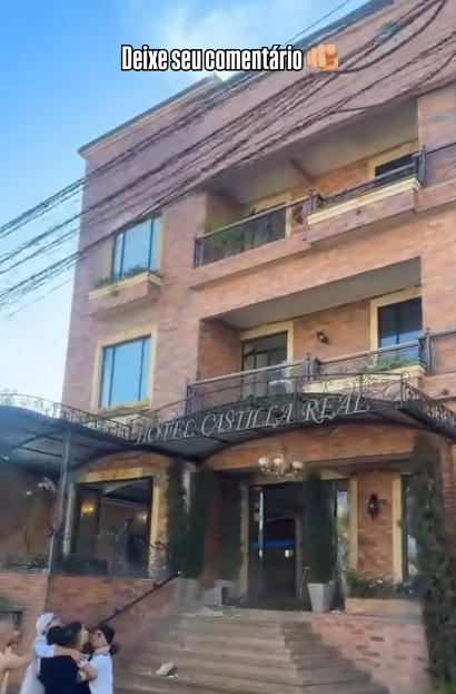 Imagens mostram um hotel tremendo em meio a um terramoto. A fachada do hotel é composta por três andares visíveis acima da entrada do térreo, com janelas de vidro emolduradas e varandas de ferro forjado no segundo e terceiro andares. Em um letreiro acima da entrada do térreo está grafado o nome do hotel: Castilla Real.