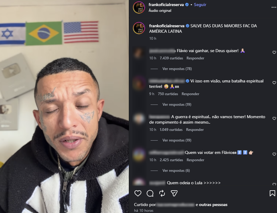 A imagem mostra uma captura de tela de uma publicação em uma rede social. À esquerda, aparece um homem de cabelo curto e tatuagens no rosto, usando uma blusa preta e branca, falando diante da câmera. Ao fundo, estão expostas as bandeiras de Israel, do Brasil e dos Estados Unidos, além de placas na parede. À direita, aparece a publicação do perfil verificado 'frankoficialreserva', com o texto 'SALVE DAS DUAS MAIORES FAC DA AMÉRICA LATINA'. Abaixo, há comentários de usuários, incluindo 'Flávio vai ganhar, se Deus quiser!', 'Vi isso em visão, uma batalha espiritual terrível' e 'A guerra é espiritual... não vamos temer! Momento de rompimento é assim mesmo.'. Outro comentário pergunta 'Quem vai votar em Flávio BR', acompanhado de emojis.